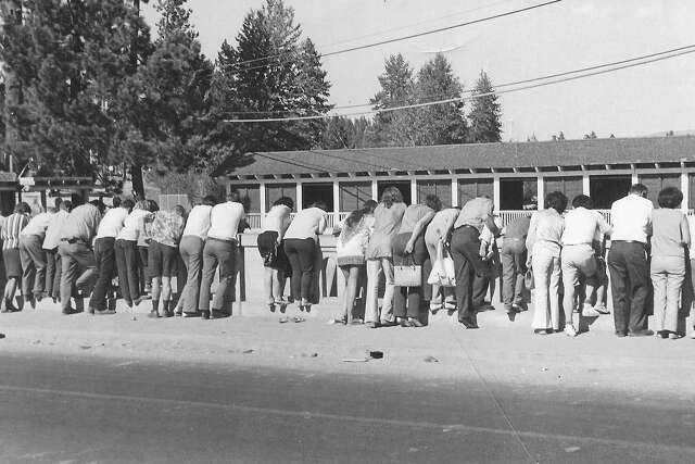 Image courtesy Gatekeepers Museum circa 1970. A black-and-white photo of people peering over the bridge, leading to the name Fanny Bridge.