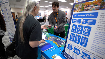 A placer employee speaking with a woman at a Discover and Discuss Community event.