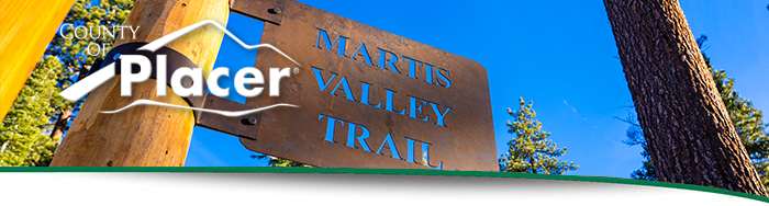 Tahoe newsletter header - an image of a metal Martis Valley Trail sign on a blue sky day.