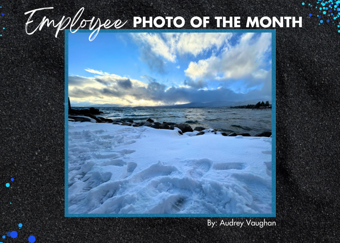 Snow-covered rocks on the beach with moody dark clouds over Lake Tahoe 
