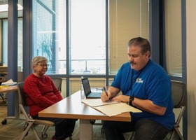 Client sitting with tax preparation assistant at a table