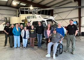 Class of eleven academy students and two deputies in front of the Sheriff’s helicopter