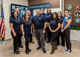 Veterans Services Office staff stand in the Rocklin office wearing blue shirts underneath their VSO logo