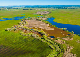 An aerial view of Yankee Slough with green land and a stream