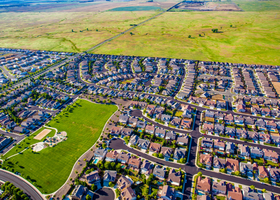 Large suburban neighborhood with a large park backs up to a wide open green field