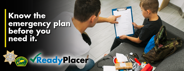 Father and son sitting on a couch reviewing an emergency go-bag checklist. Text reads Know the emergency plan before you need it