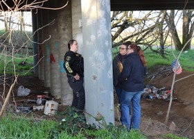 Social workers and Probation personnel stand beneath an overpass during the annual Point In Time count