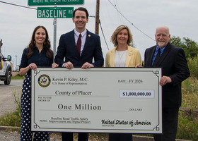 Supervisor Landon, Rep Kiley, Supervisor Gore and Public Works Director Derek Gade hold a large check for $1 mill under the Baseline Road sign