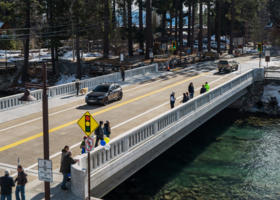 Concrete bridge in Tahoe City with cars and people on it.