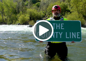 CEO Daniel Chatigny w the County Line sign in the river