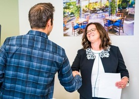 Woman shaking a man’s hand in a professional environment