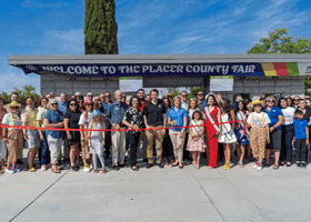 3 rotating pics of the fair including the ribbon cutting, a Ferris wheel and a Placer employee showing a girl a dog. 