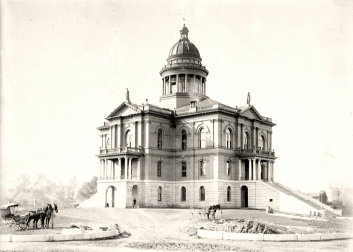 Historical photo of the large stone and brick multi-story Placer Courthouse building with large outside staircases.