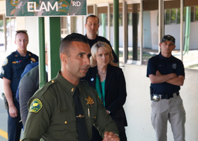 A Placer Sheriff’s deputy leading five people on a tour in front of its new training academy