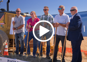 Members of Placer County’s Department of Public Works posing for a photo with shovels, with a video play button over top