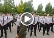 Law enforcement recruits stand at attention in shirts and ties as in instructor walks past them at the Placer County Sheriff Training Academy