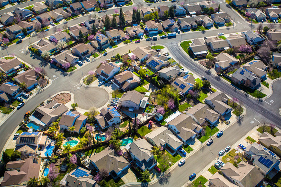 Aerial overview of a cul de sac neighborhood featuring modeled homes with green lawns, and pools