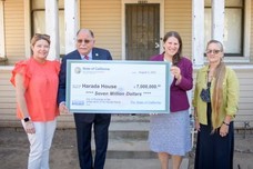 Councilmember Edwards and others at check presentation for Harada House rehabilitation