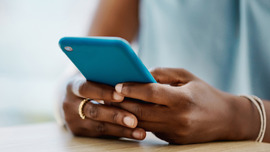 Close up of hands holding a blue cellphone