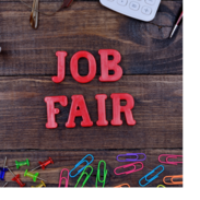 The words, "job fair," sit on a table surround by thumb tacks, paperclips, a calculator and pens.