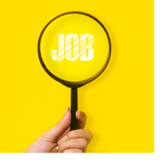 A hand holds a magnifying glass over the word "job."