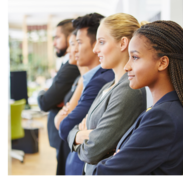 Five young men and women standing in a row. They are dressed in business apparel and crossing their arms.