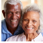 A smiling older man and older woman poses for a photo together