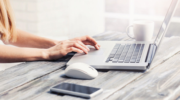 Hands typing on a laptop