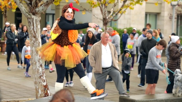 Photo of a woman dressed in a Turkey Costume dancing in a crowd of people