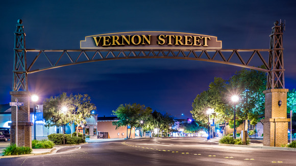 Photo of the Vernon Street archway at night time, welcoming you into a brightly-lit Downtown Roseville