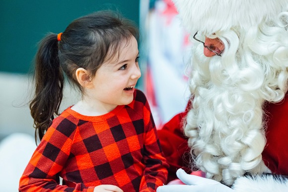 Photo of a toddler girl smiling at Santa