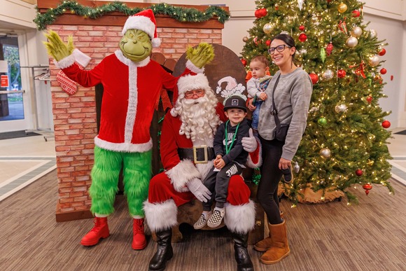 Photo of two children with the Grinch and Santa
