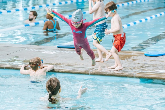 Photo of a young child jumping into the pool during a swimming lesson
