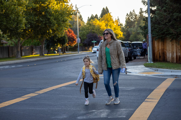 Photo of a mother walking her daughter in a crosswalk