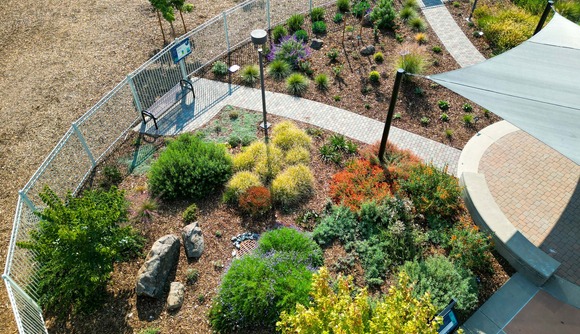 Aerial photo of the Inspiration Garden. Various native bushes blossom in colors of deep green, orangey reds, and soft purples.