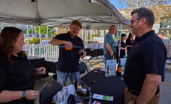 Two people chat with a Wine Down Wednesday vendor
