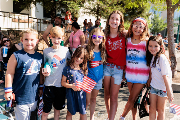 A group of children wearing 4th of July-themed clothing pose and smile