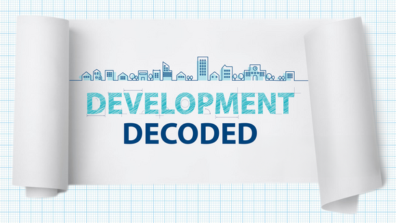 A scroll graphic sits atop a grid background. A sketch of a city skyline hovers above text that reads, "Development Decoded"