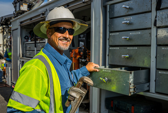 A water Utility employee smiles while opening a tool drawer
