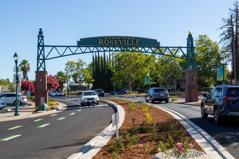 An archway on Vernon Street reads, "Downtown Roseville." Traffic flows on either side of the street.