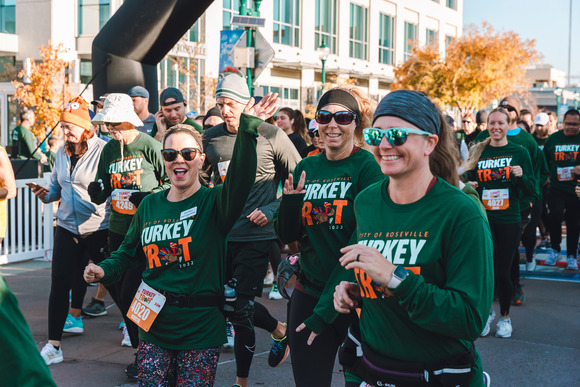 A group of racers smile while finishing the Turkey Trot finish line