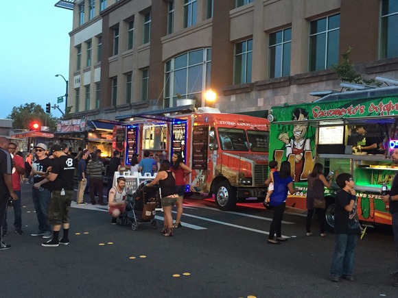 Attendees stand in line for food trucks, which line up Oak St