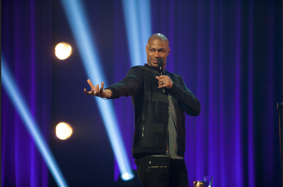Finesse Mitchell talking into a microphone onstage