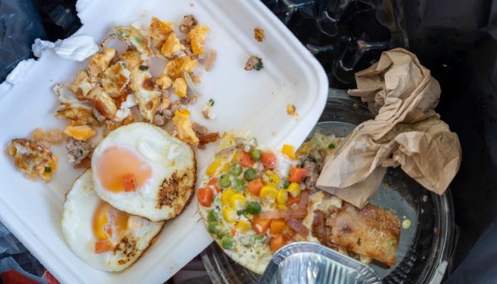 Foam takeout container with breakfast scraps