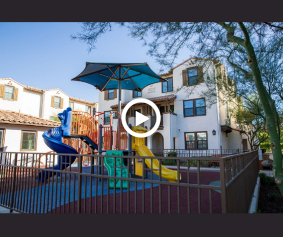 A outside picture of the exterior of housing complex with playground.