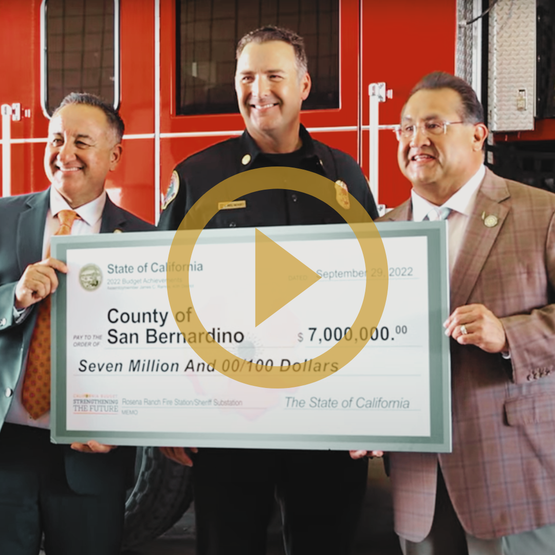 San Bernardino County Supervisor Joe Baca, Jr., County Fire Protection District Chief Dan Munsey, and State Assemblyman James Ramos accept a check.