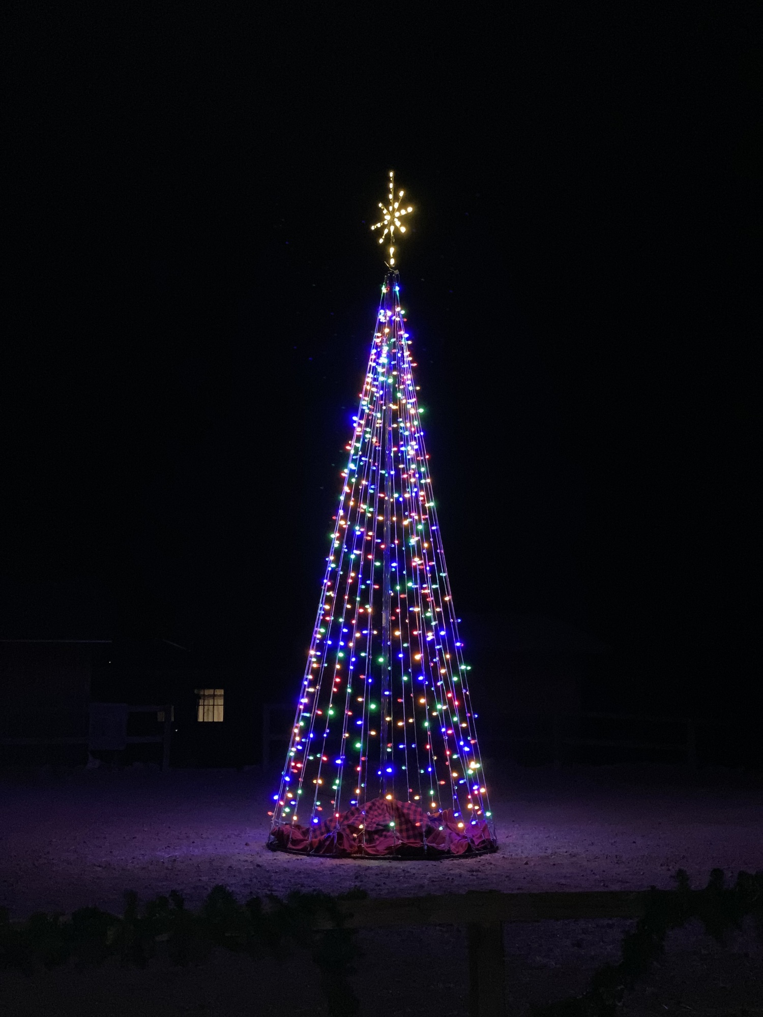 A night time photo of a Christmas tree all lit up at Calico Ghost Town.