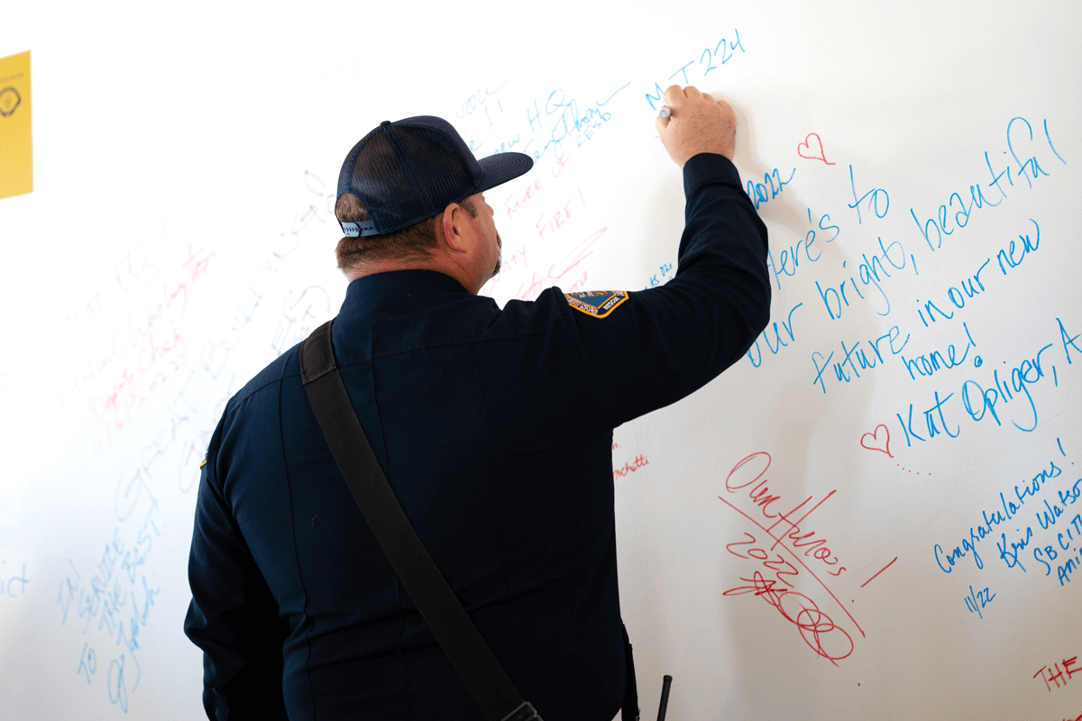 A SB County Firefighter signs a dedication wall at the new planned HQ site.