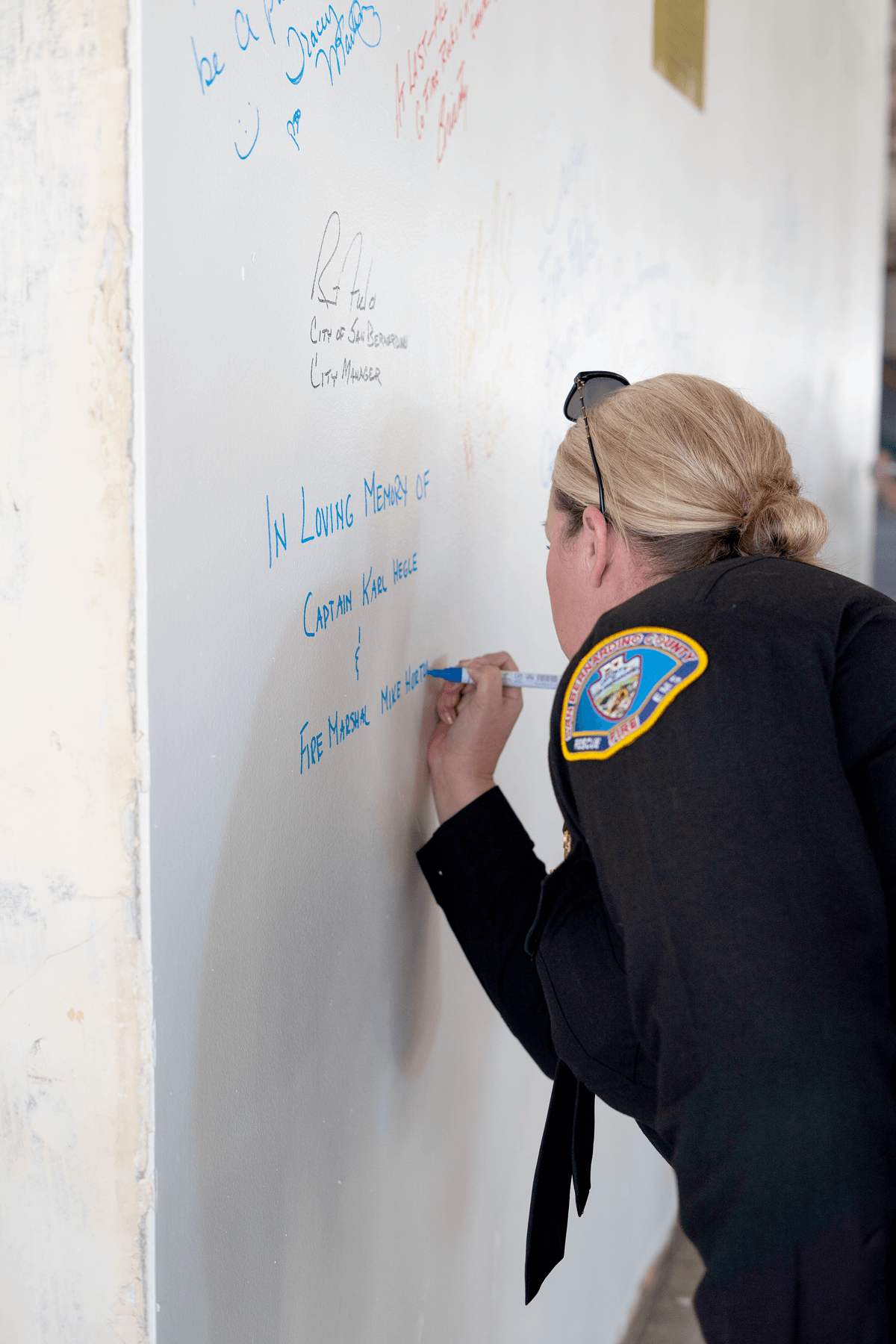 A SB County Firefighter signs a dedication wall at the new planned HQ site.