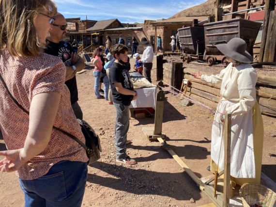 A man and woman stand by to watch a little boy learn how to make rope at Calico California Days.